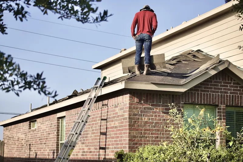 Professional roofer working on a residential roof in Village of the Branch